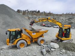 Elev på maskinførerkurs fra Presto Training AS bruker gravemaskin til å laste dumper med masser på anleggsplass.
